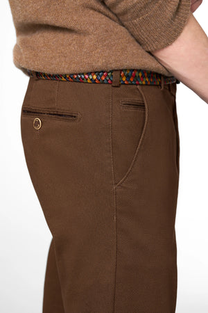 Brown pants with a colorful belt on a white background